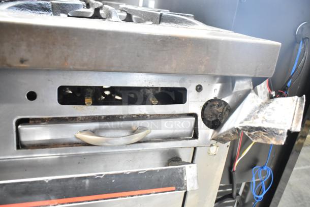 Garland commercial gas 4-burner range with oven, over shelf, backsplash; used condition with visible wear.