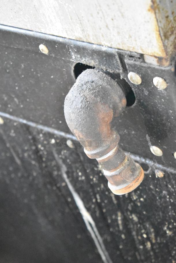 Garland commercial gas range, 4 burners, oven, over shelf, backsplash, visible rust on pipe, wear shown.