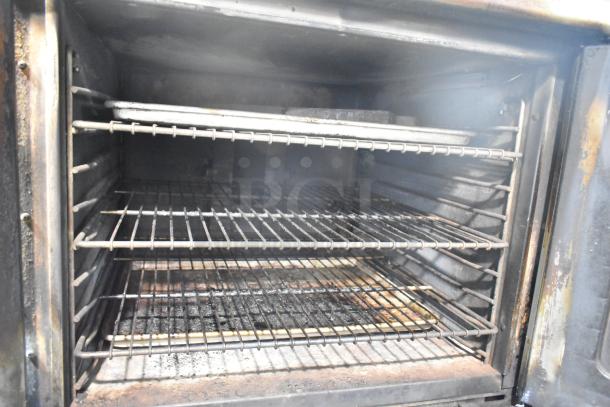 Montague commercial convection oven interior view, showing racks and slight wear. View-through doors, thermostatic controls.