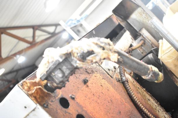 Montague commercial convection oven detail, showing wear and rust on gas component. Oven in used condition.