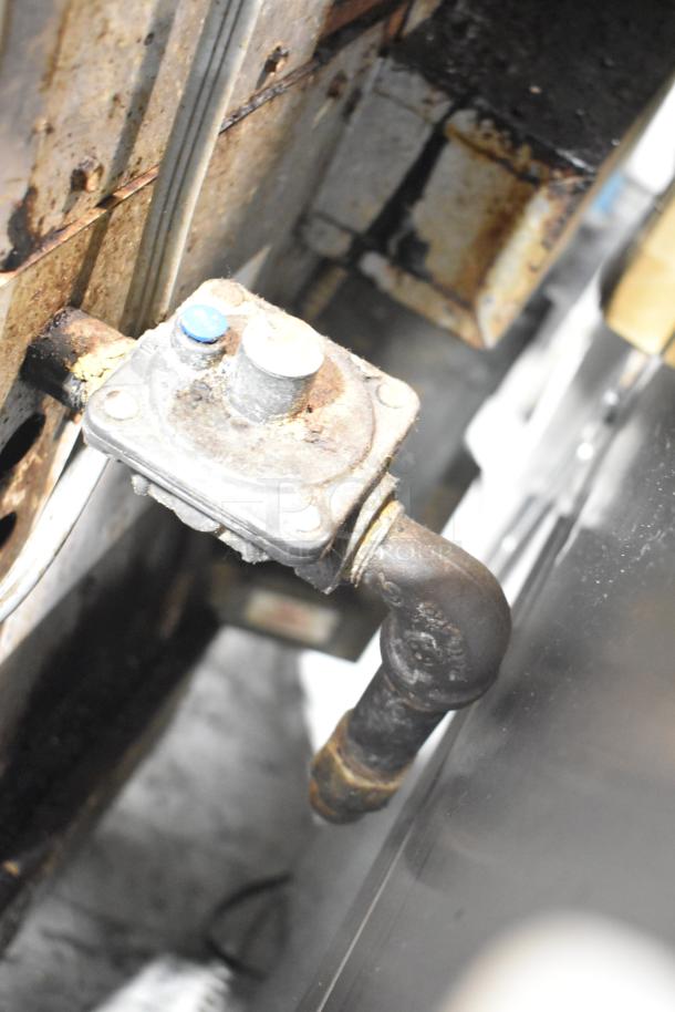 Montague commercial gas oven component with rusted fittings, indicating wear. Includes view-through doors and thermostatic controls.