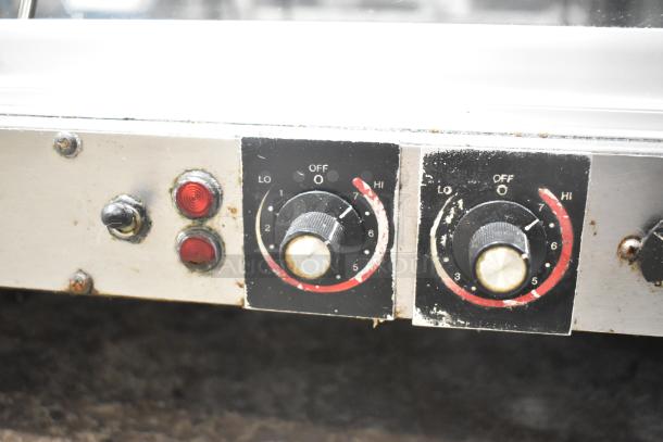 Hatco Commercial 2-Tier Warming Display Case controls, showing two dials with temperature settings and indicator lights.