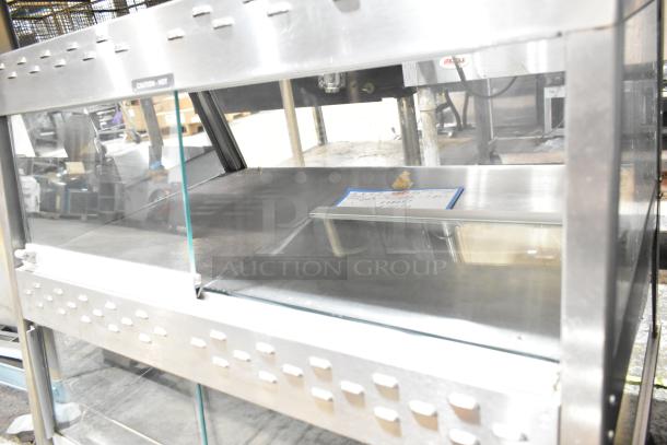 Hatco 2-tier warming display case merchandiser, stainless steel with glass doors, featuring "Caution - Hot" label.