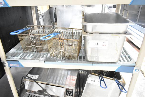 Two fryer drop-in bins and two fry baskets on a shelf. Bins with labels "141 QTY 4." Baskets have blue handles.