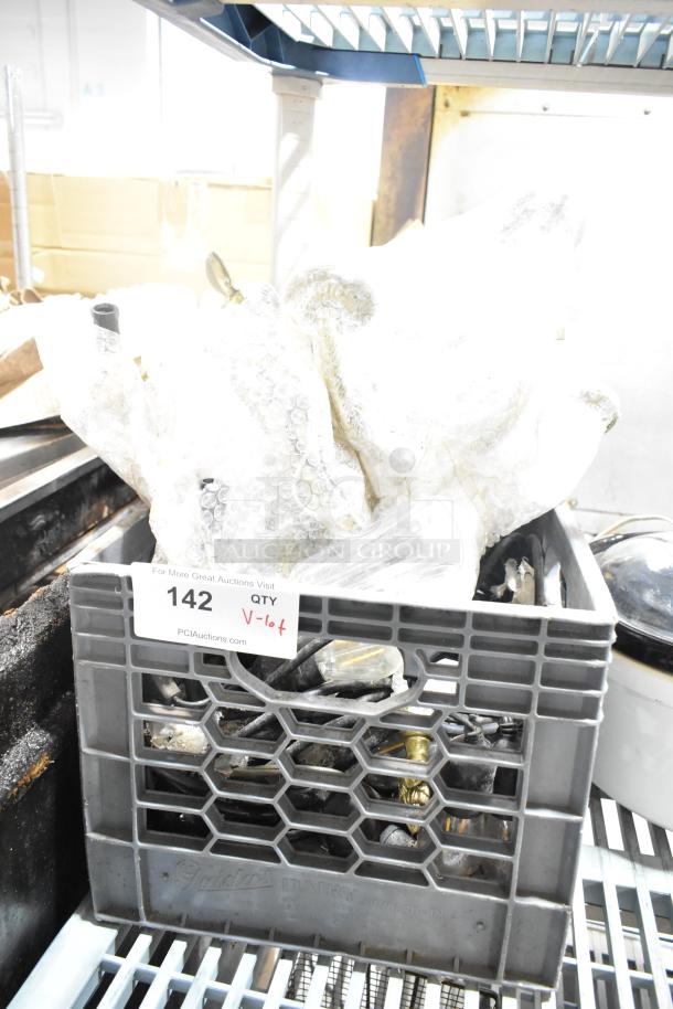 Crate with assorted items including light string, light fixture, bubble-wrapped. Auction tag "142, QTY V-lot" visible.