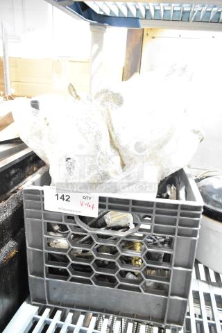 Crate with assorted items including light string, light fixture, bubble-wrapped. Auction tag "142, QTY V-lot" visible.