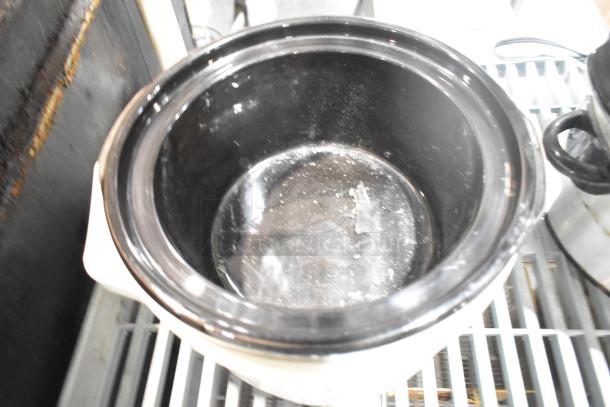 Two slow cookers including Rival 3950 and Crock Pot SCV803-SS on a metal shelf, 120 volts, used condition.