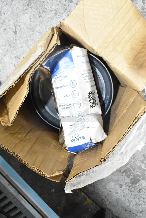 Box containing a water filter replacement cartridge and Aladdin Temp-Rite black poly trays; packaging is slightly worn.