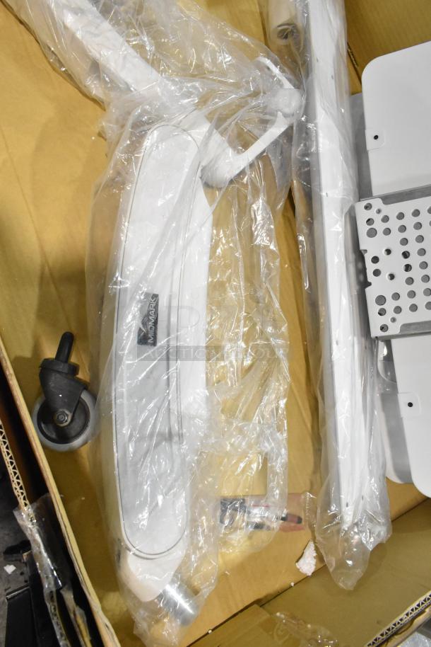 Three new Midmark 6282-001 Shroud Kits in packaging, labeled "Midmark," showcasing components and wheels.