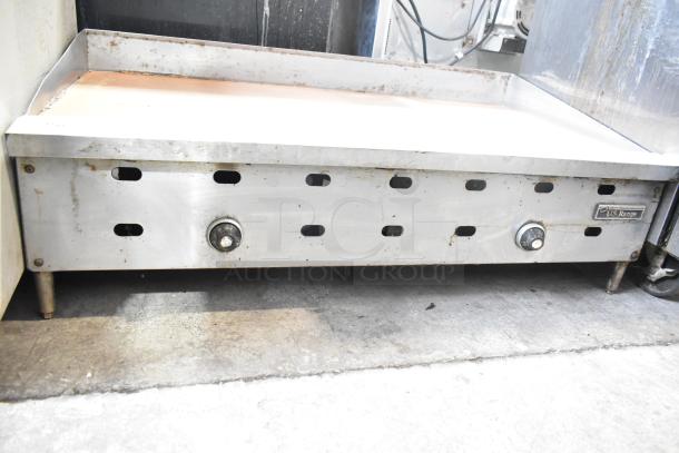 US Range commercial countertop gas griddle, stainless steel, three control knobs, moderate wear, branded label visible.