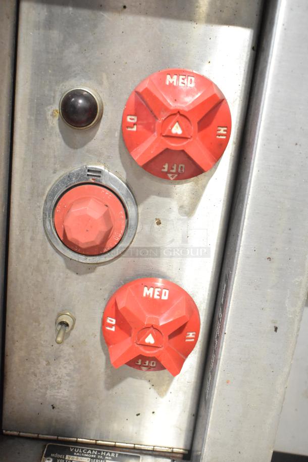Vulcan V008-T pizza oven controls with red dials labeled "MED," "LO," "HI," and "OFF," indicating temperature settings. Model plate visible.