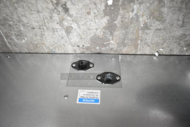 Hoshizaki DCM-300BAH commercial icemaker base with visible mounting ports and label indicating plastic fitting notice.