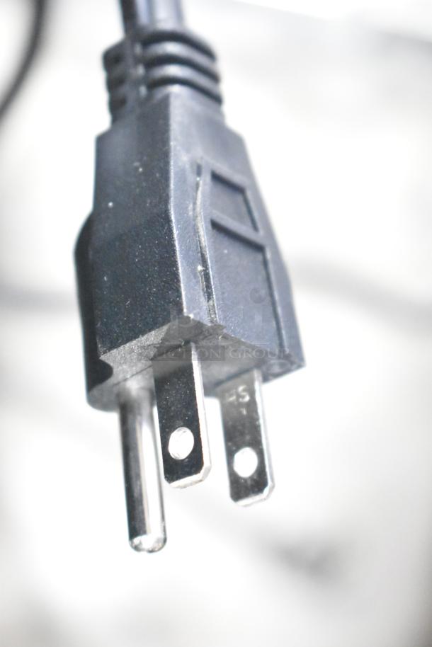 Close-up view of a 3-prong power plug, likely for the Avantco 177HDC26 heated display case, showing blade and ground pins.