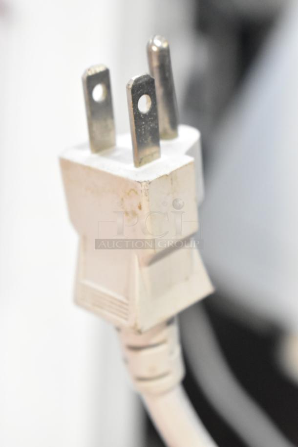 Close-up of a white, three-pronged power plug, likely for the Panasonic NN-SA651S microwave.