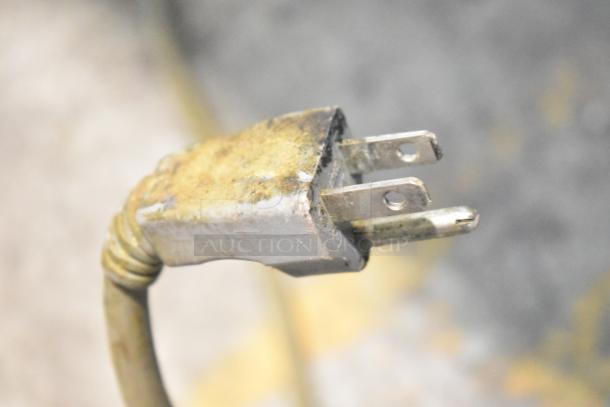 Close-up of a power plug with visible wear and tarnish on the prongs, likely from the 2016 Amana RMS10TS Microwave.