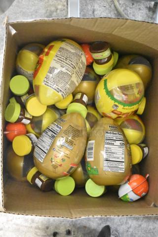 Box filled with assorted candy containers, featuring nutrition labels. Includes various branded sweets.