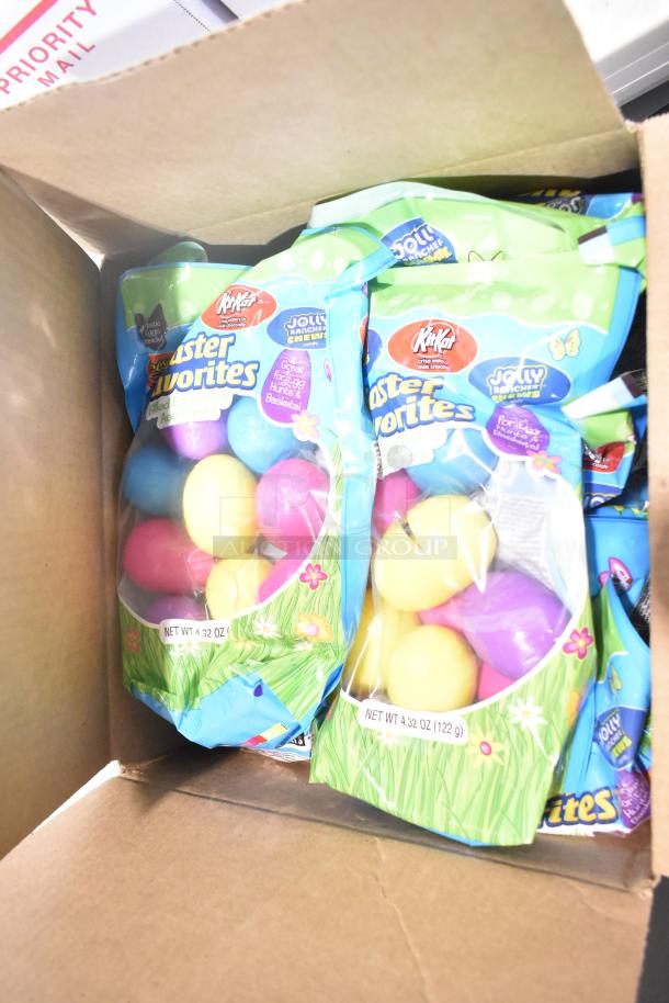 Box containing various candy bags; visible labels include KitKat Easter Favorites, Jolly Rancher flavors in pastel egg shapes.
