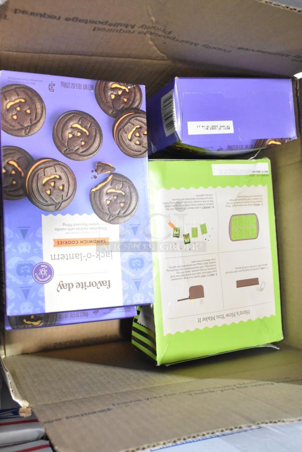 Assorted candy boxes including Favorite Day Jack-O-Lantern Sandwich Cookies in a cardboard box.