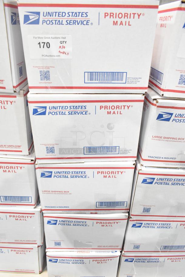 Stacked USPS Priority Mail boxes containing 10 boxes of assorted candy, including Jef Puffed Marshmallows and Reese's.