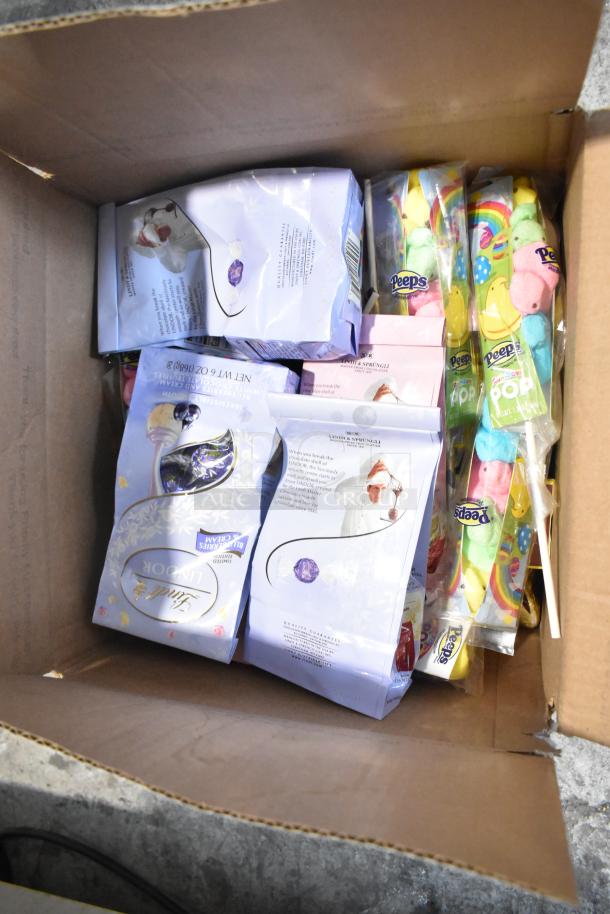 Open box showing assorted candy including Peeps, Lindt chocolates, and other treats. Ideal for bulk purchase.