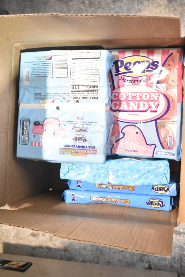 Box of various candies including Peeps Cotton Candy and Chocolate Pudding flavors. Unopened packages, assorted selection.