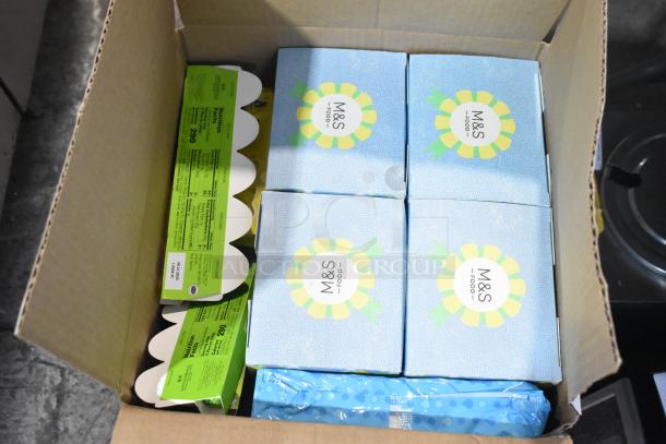 10 boxes of various candies, including M&S labeled items, in a cardboard box, showcasing nutritional labels and packaging.