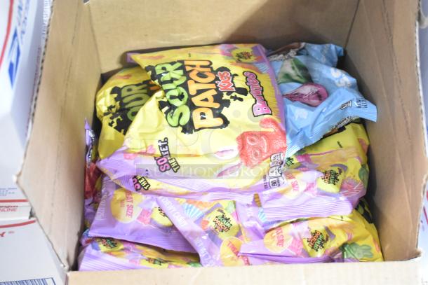 Open box with packs of Sour Patch Kids Bunnies candy. Various pastel packaging visible.