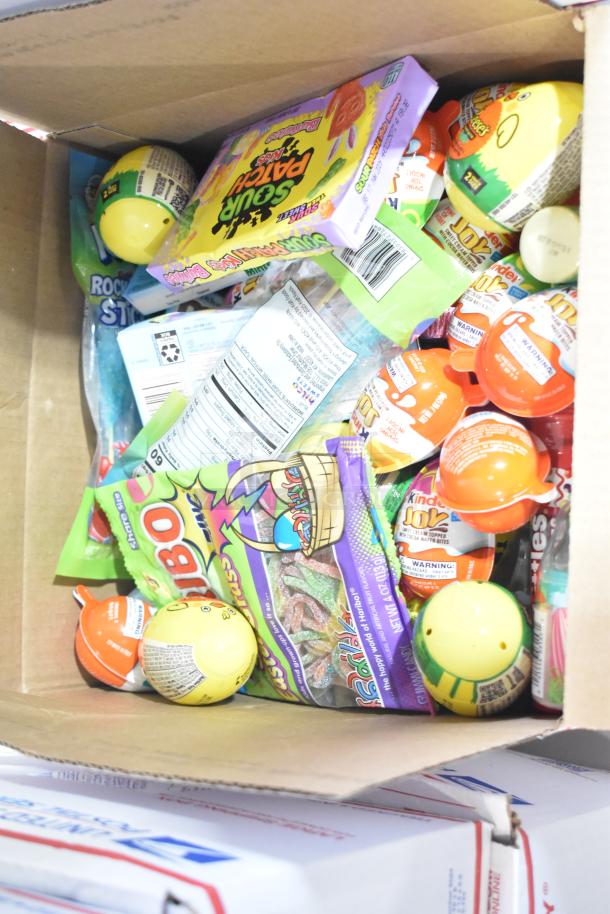 Box of assorted candy including Reese's, Sour Patch Kids, Kinder Joy, and more. Various brands and types showcased.