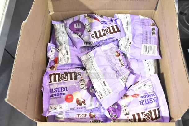 Box with multiple purple bags of M&M's Easter Sundae flavor. Each bag labeled "white & dark chocolate" and nutrition info visible.