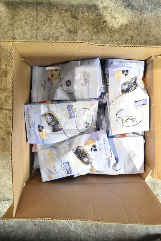 Box containing multiple Lindt Lindor bags with blueberry and cream flavor, in original packaging.