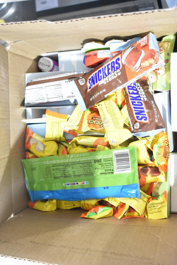 Box of assorted candies including Snickers, Reese's, and Starburst. Contains chocolate bunnies and cotton candy Peeps.