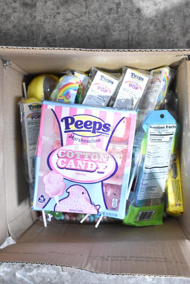 Box containing various candies including Peeps Cotton Candy, chocolate bunnies, chocolate crosses, and Starburst jellybeans.