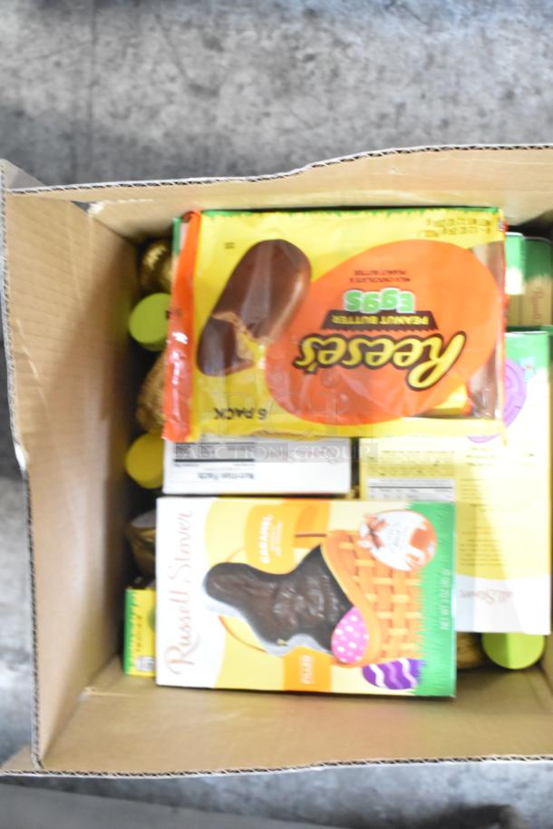 Box of assorted candies including Reese's Peanut Butter Eggs, Russell Stover Chocolate Bunnies, and various Easter treats.