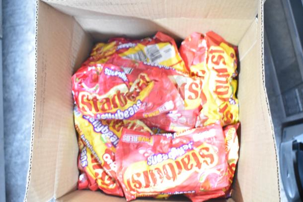Box containing multiple packs of Starburst jellybeans, featuring vibrant red and yellow packaging.