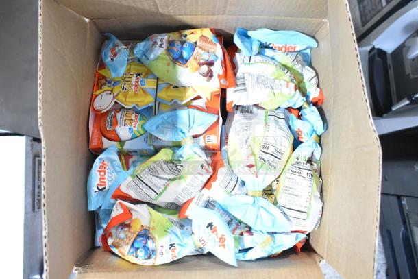 Box of assorted Kinder chocolate packs, featuring colorful packaging. Items are sealed, indicating freshness.