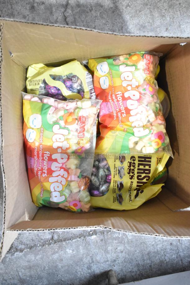 Box of assorted candy including Jet-Puffed marshmallows, Starburst jellybeans, and chocolate bunnies in original packaging.