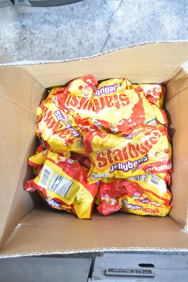 Box filled with Starburst Jellybeans bags, part of a lot including Jet Puffed Marshmallows and chocolate bunnies.