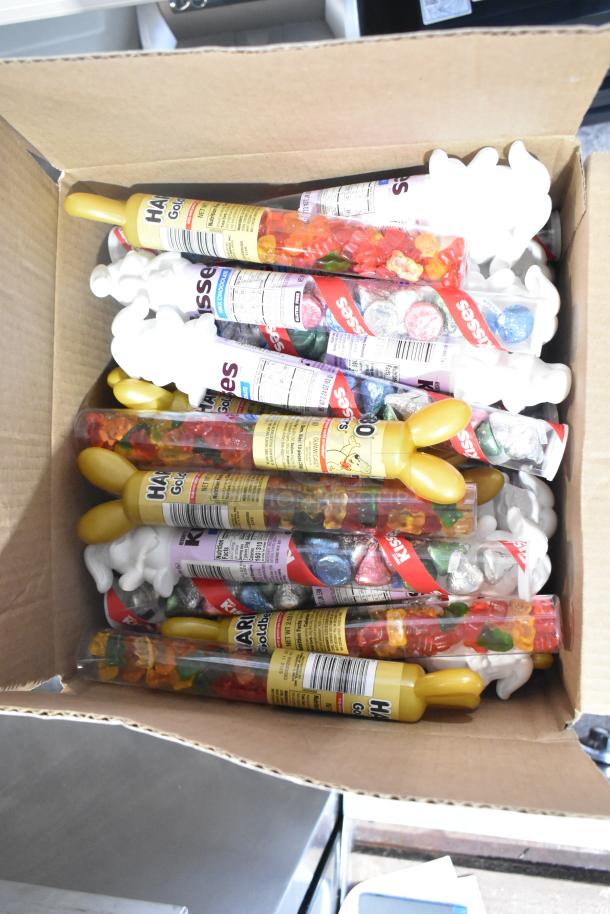 Box containing assorted candy including Haribo gummies and Hershey's Kisses, showcasing multiple candy tubes.