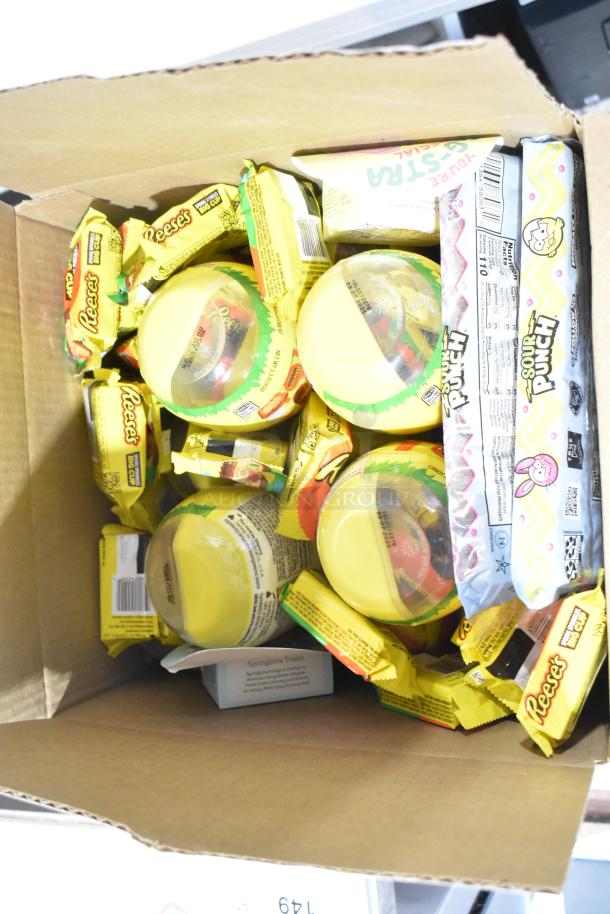 Cardboard box filled with various candies including Reese's, Sour Punch, and more. Items in new condition.