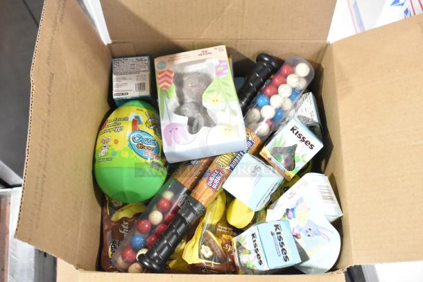 10 boxes of assorted candy including Jet-Puffed Marshmallows, Starburst Jellybeans, chocolate bunnies, in cardboard box.