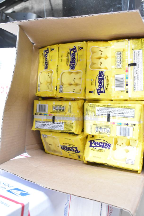 Open box of yellow Peeps candy, showing multiple packs. Item includes 10 boxes of assorted candy like Junior Mints and Kinder Joy Eggs.
