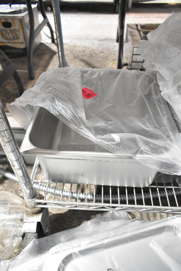 Brand new Vigor stainless steel drop-in bin on a metal shelf, covered in plastic, with a red tag visible.