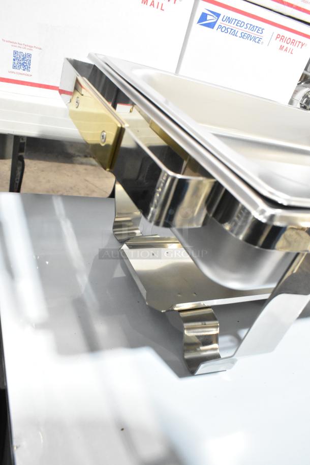 Brand new chafer with minor scratches, stainless steel construction, polished finish, and elegant curved legs.