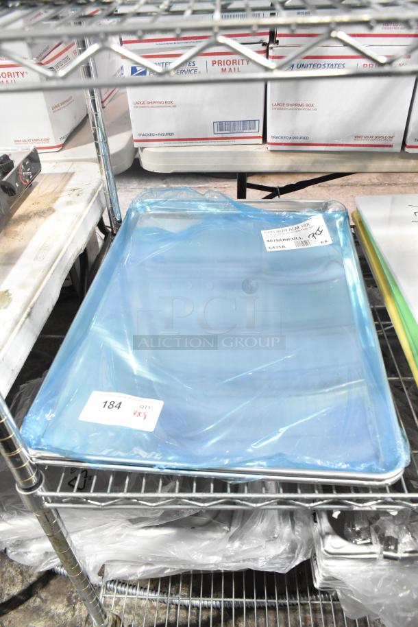 8 brand new baking pans and cutting boards, wrapped in plastic, noted as "scratch and dent," item tag visible with "184 QTY X 5."