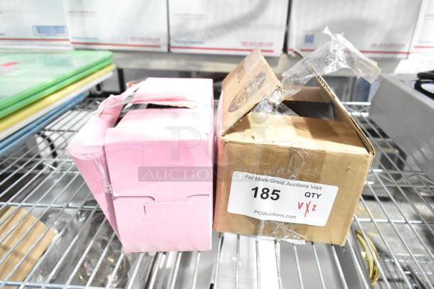 Two boxes labeled "185" on shelving, containing new items: LED light bulbs and pilot tube assembly. Packaging is taped and dented.