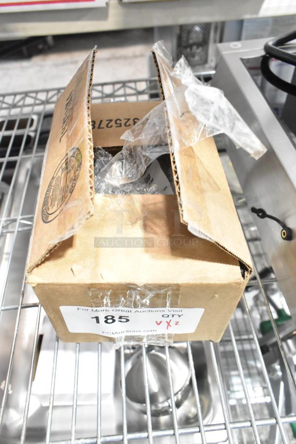 Cardboard box containing scratch and dent items, including LED light bulbs and pilot tube assembly. Box labeled for auction.