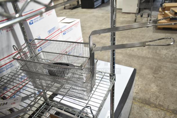 Steel wire fry basket with long handle on metal shelf, USPS boxes in background. Perfect for commercial kitchen use.