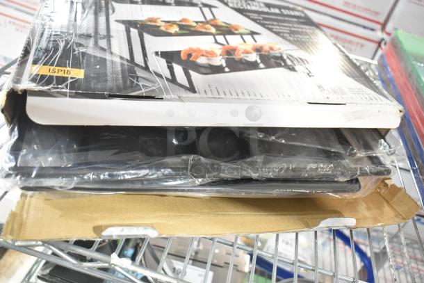 Brand new American Metalcraft ISP18 3-tier black riser stand in packaging, label showing model with minor box damage.