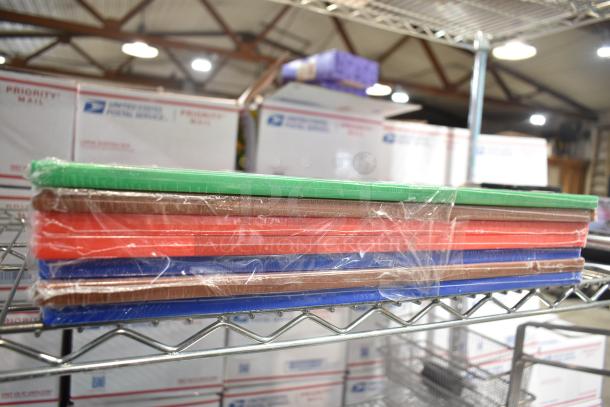7 new cutting boards, scratch and dent, 2 red, 2 brown, 2 blue, 1 green, stacked on a shelf, wrapped in plastic.
