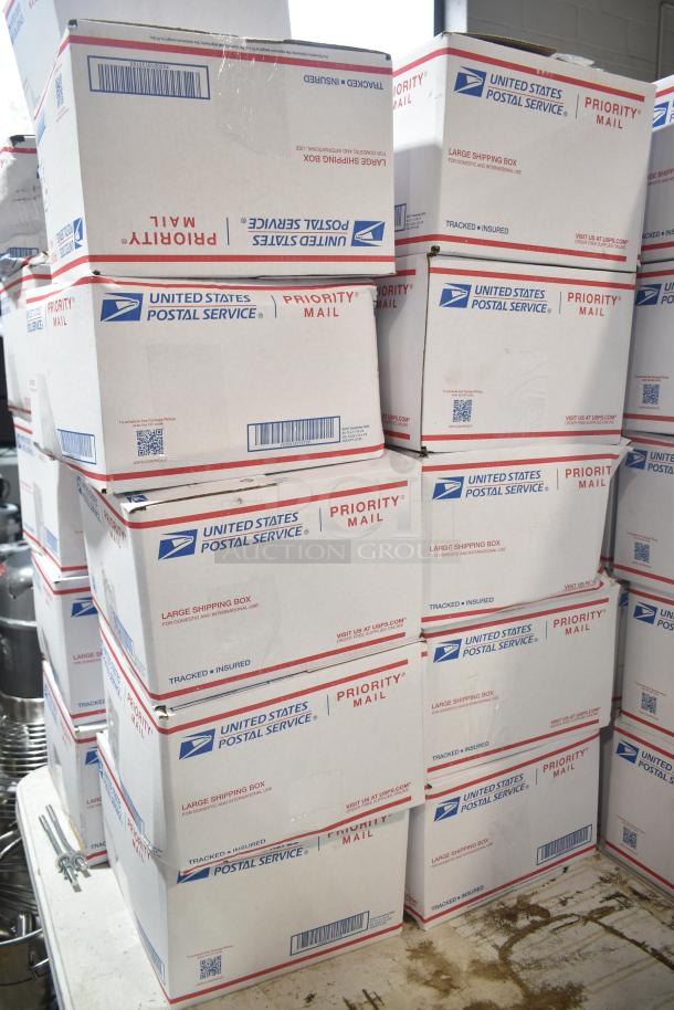 Ten USPS Priority Mail boxes of assorted candy, including Reese's Bunnies, stacked, ready for auction.